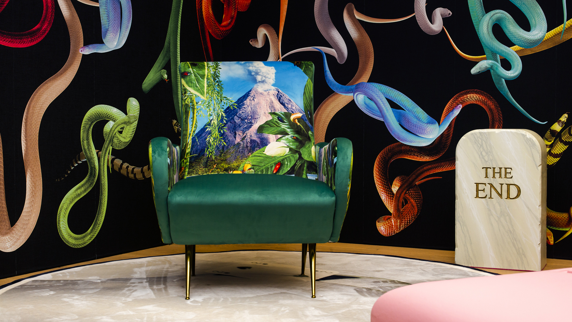 Chair with mountain print in front of snake wallpaper.
