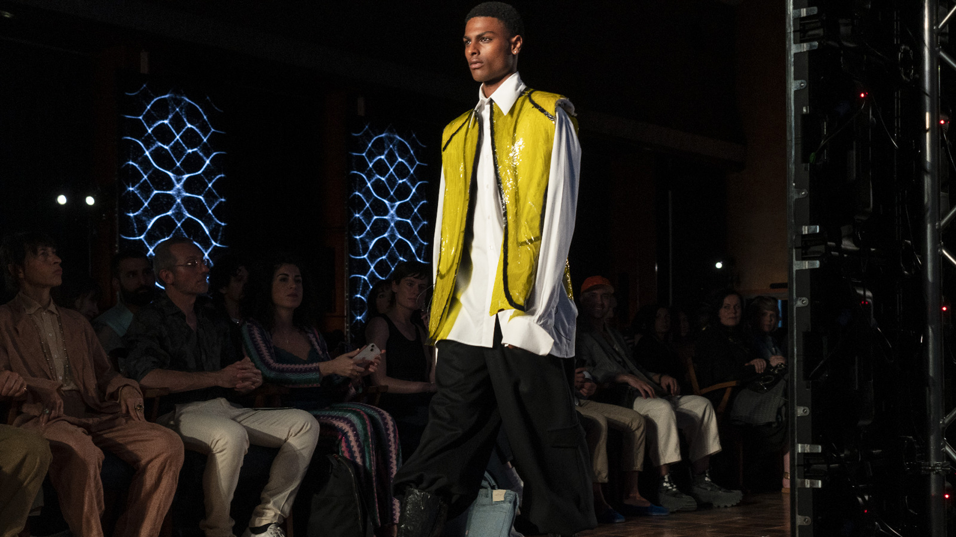 Young guy on catwalk wearing white shirt with yellow jacket